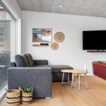 Wohnzimmer mit Sofa, Fernseher und Billardtisch. Große Glasfront zum Balkon.