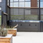 Outdoorwhirlpool mit Holzumrandung und Schneebedeckung im Gartenbereich