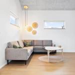 Wohnzimmer mit grauem Sofa, runden Tisch und Holzboden.