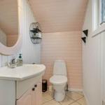 Badezimmer mit Waschbecken, Toilette und Spiegel an der Wand.