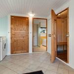 Waschraum mit Sauna und Bad. Holztüren, Fliesenboden und Waschmaschinen.