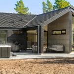 Modern villa with hot tub, grill, and large terrace with seating areas.