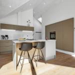 Modern kitchen with island, two bar stools, and built-in oven.