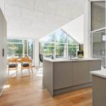 Modern kitchen with island, hardwood floor, and large windows for views.