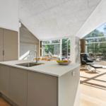 Kitchen with island and view of living area with seating.