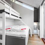 Room with bunk bed, windows, and wooden floor.