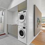 Apartment with washer and dryer, kitchenette, and view of dining area.