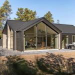 Modern house with large glass area and outdoor terrace with seating.