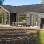 Modern wooden house with large glass area and terrace in the woods