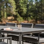 Terrace with table and chairs. Forest in background.