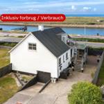 Weißes Haus mit Garage und Terrasse am Wasser