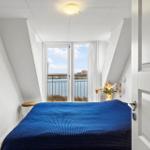 Schlafzimmer mit Balkonblick auf Wasser und Himmel