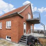 Rotes Backsteinhaus mit Balkon und Terrasse an Wasser