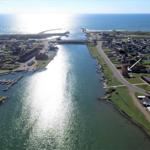Häuser am Wasser, Hafen und Meer im Hintergrund
