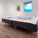 Schlafzimmer mit Bett, Nachttisch und Fenster.