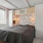Schlafzimmer mit Bett, Wandverkleidung und integriertem Schrank.