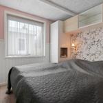 Schlafzimmer mit Bett, Fenster und Wand mit Blumenmuster.