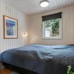 Schlafzimmer mit Bett, Fenster und Wandbild.