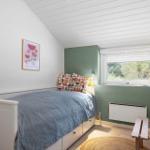 Schlafzimmer mit Bett, Fenster und Holzbank.