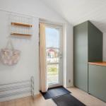 Eingangsbereich mit Waschmaschine, Garderobe und Tür zum Garten.