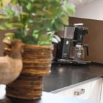 Küchenarbeitsplatte mit Kaffeemaschine und Pflanze in Korb.