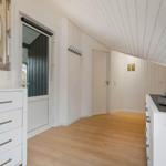 Wohnbereich mit weißen Schränken, Holzboden und Spiegelschrank