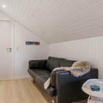 Schwarzes Sofa mit Felldecke, weißer Wandschrank und Bild an der Wand.
