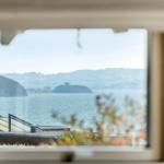 View through a window to a lake with islands and hills in the background.