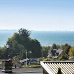 View of the sea with trees and houses in the foreground.