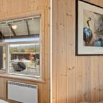 Holzwand mit Bild und Blick auf Terrasse mit Tisch und Stühlen