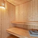 Sauna mit Holzwand, Sitzbänken und Handtuch.