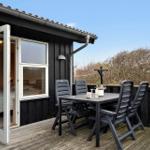 Terrasse mit Tisch und Stühlen neben einem Haus mit offener Tür.