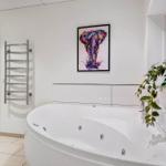 Bath with whirlpool, wall heater, and wall art