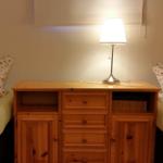 Zwei Betten flankieren einen Holzschrank mit Lampe.