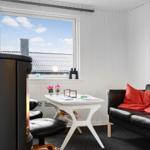 Raum mit Sofa, Tisch und Kamin, großes Fenster mit Blick auf Dach.