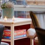 Tisch mit Kerzen und Spielboxen vor Fenster