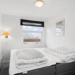 Schlafzimmer mit Doppelbett, Fenster und Wandlampen.