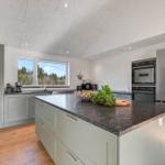 Modern kitchen with island, stainless steel appliances, and hardwood flooring.