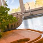 Kitchen countertop with cutting board and herb plant by window