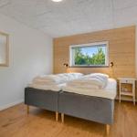 Bedroom with double bed, wooden wall, and window with forest view.