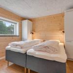 Bedroom with double bed, wooden wall, and window with forest view.