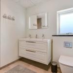 Bathroom with sink, mirror, toilet, and shower.