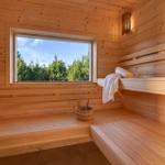 Sauna with wooden bench, window and bucket
