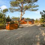 Wooden house with roof and gravel path among trees