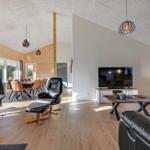 Living and dining area with leather sofas, TV, and wooden floor.