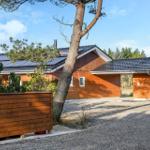 Wooden house with solar panels and tree in front yard
