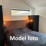 Bedroom with bed, closets, and window. Model photo.