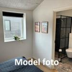 Bedroom with window and adjacent shower