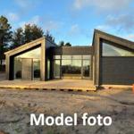 Modern wooden cabin with large windows and terrace in the forest