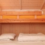Zimmer mit Doppelbett und oberem Bett mit gelber Bettwäsche.